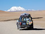 04 Gang Benchen And Our Landcruiser From Between Friendship Highway And Shishapangma Checkpoint Our Landcruiser drives on the road from the Friendship Highway to the west with Gang Benchen ahead.